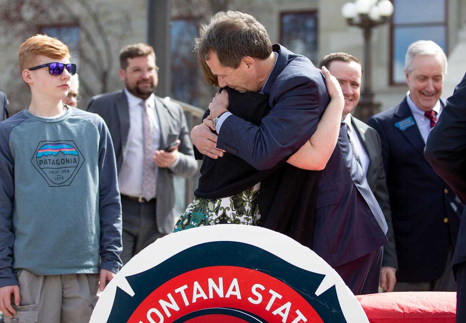 After the bill signing, Gov. Steve Bullock hugs Jill Baker,